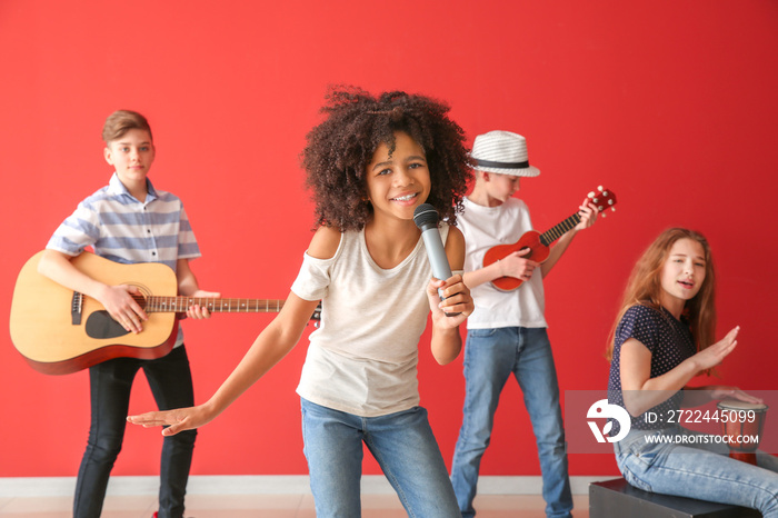 Teenage musicians playing against color wall