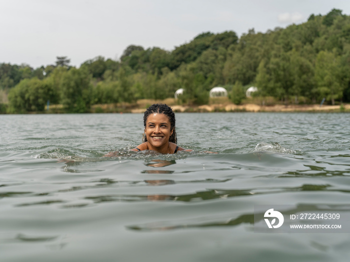 Smiling woman swimming in lake