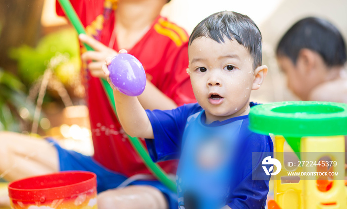 Little Asian boy playing water outdoor house  summer time