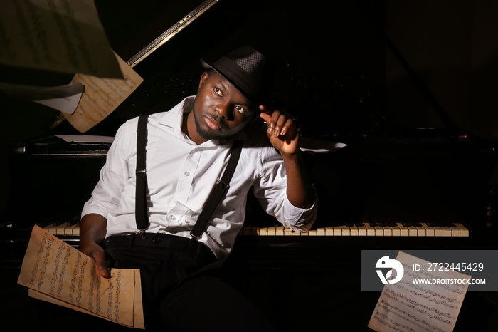 Afro American man in hat with piano