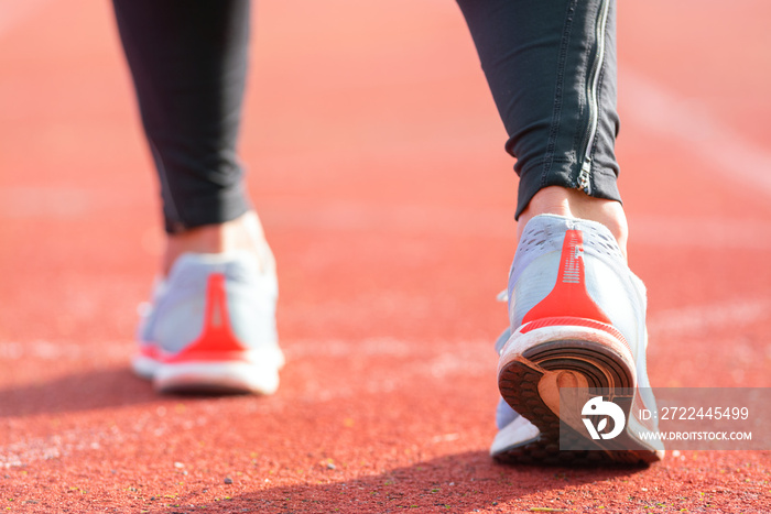 close up view of an athlete getting ready for the race on a running track . Focus on shoe of an athlete about to start a race in stadium .