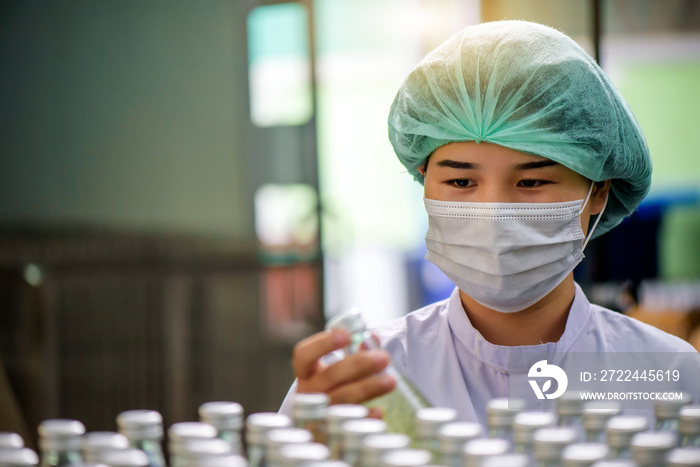 Quality control woman and manager wearing a lab coat to checking juice industrial process at factory. Teamwork at production line successful concept.