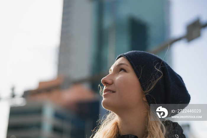 urban portrait of teen girl walking in the city in autumn or spring