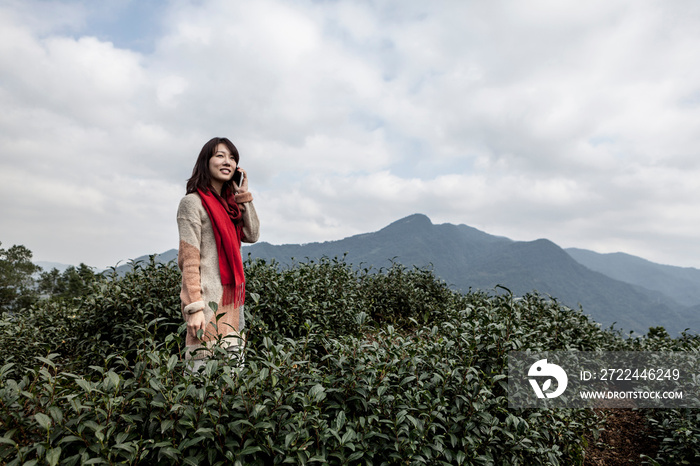 Young woman on cell phone on tea plantation