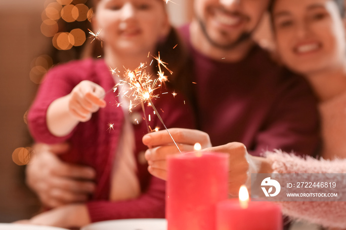 Family with sparklers celebrating Christmas at home