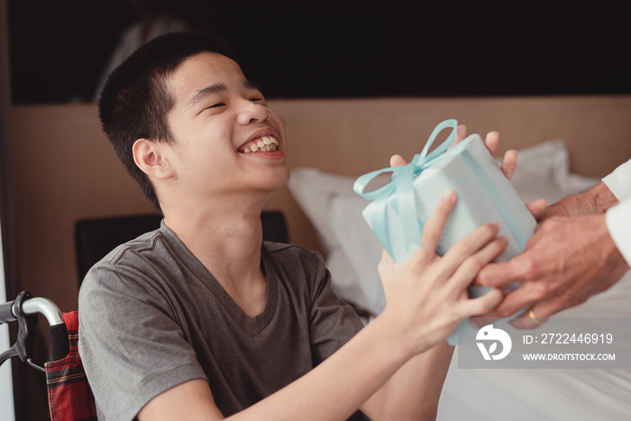 A young man with a disability smiling face glad to receive a gift.