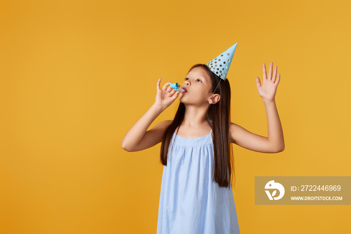 happy little birthday girl with party cone hat and whistle