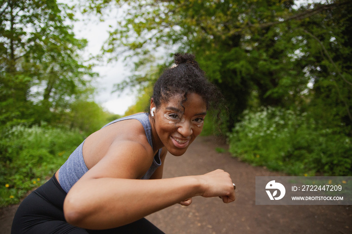 Young curvy woman with vitiligo working out in the park wearing earbuds