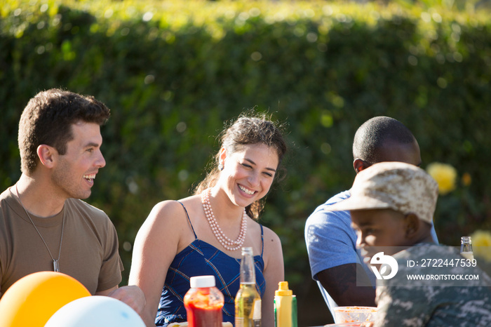 Male soldier with family and friends at homecoming party in garden