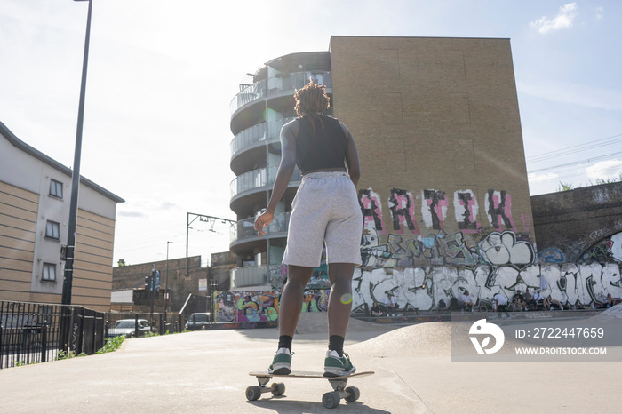 Young woman skateboarding in skate park