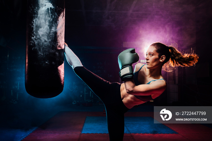 young woman training self defense giving a high kick to the punc