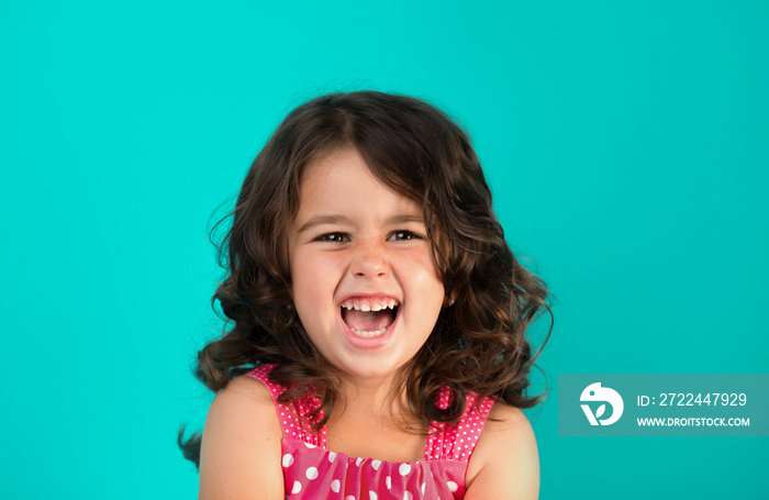 portrait of a happy, positive, smiling, little girl, cyan background