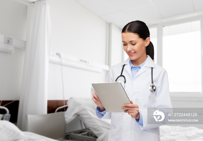 healthcare, technology and medicine concept - smiling female doctor with tablet pc computer over hospital ward background