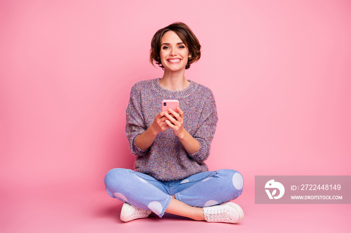 Portrait of her she nice-looking attractive lovely charming pretty cute cheerful cheery brown-haired girl sitting in lotus pose using 5g app isolated over pink pastel color background