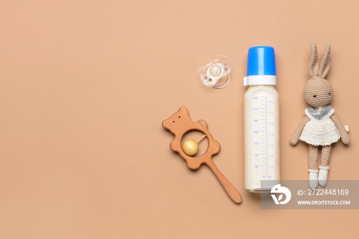 Bottle of milk for baby and accessories on color background