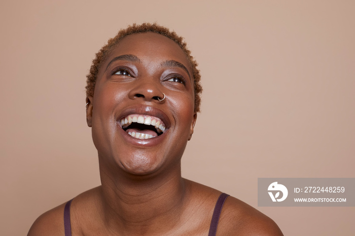 Studio portrait of smiling woman with nose ring