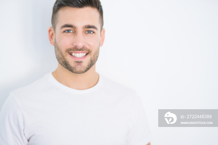 Young handsome man smiling happy wearing casual white t-shirt over white isolated background