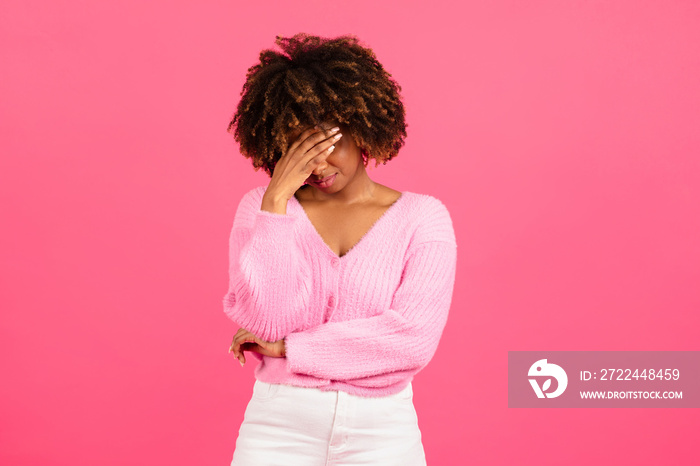 Despaired sad millennial african american curly woman in casual covering her face with hand, crying