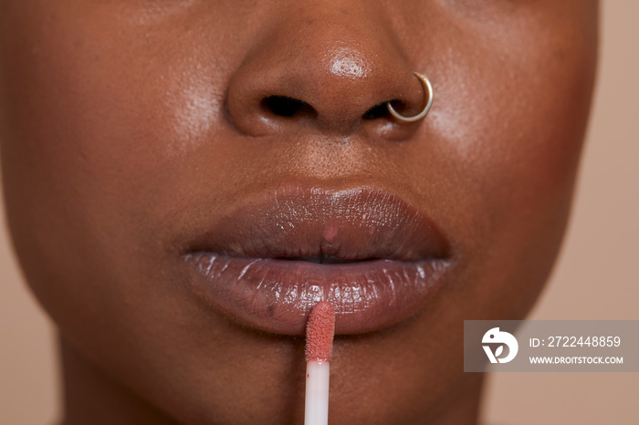 Close-up of woman applying lip gloss