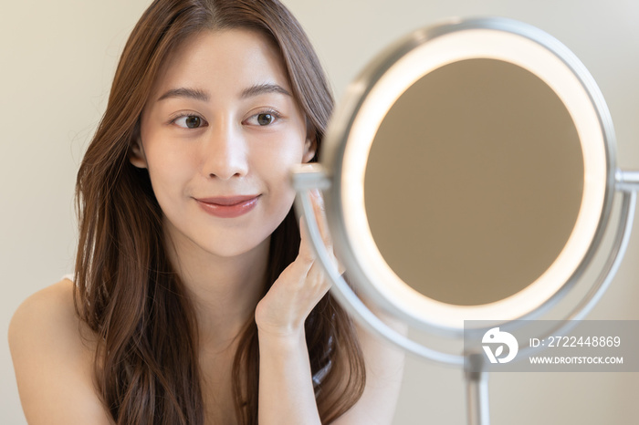 Fresh, nice healthy skin, beautiful of asian young woman, girl looking at mirror, touching her face with before make up cosmetic routine at home. Female look with natural fashion style, Facial Beauty.