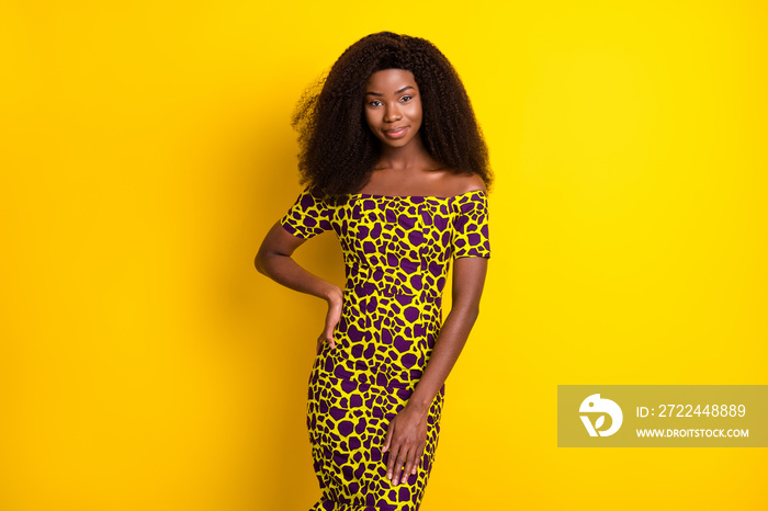 Portrait of attractive slender girl wearing shine dress posing isolated over bright yellow color background