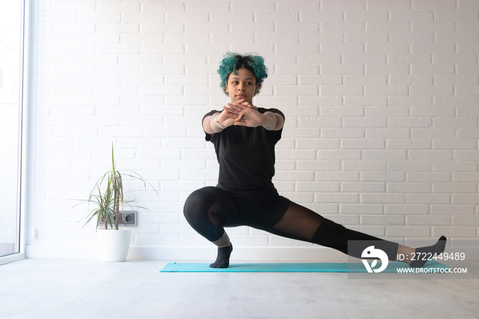 young woman wearing sportswear doing gymnastics at home or gym