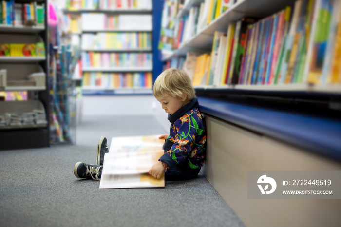 Adorable little boy, sitting in a book store