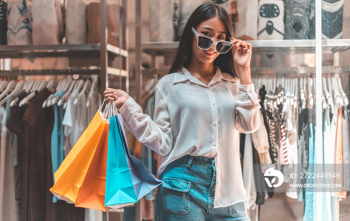 Asian woman sit rested after shopping in a colorful bag and she was happy to go shopping