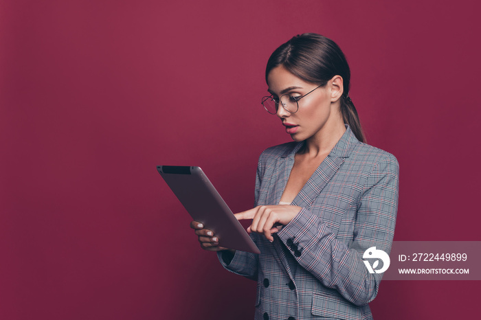 Portrait of her she nice attractive lovely pretty classy focused lady professor ceo boss chief in gray checkered blazer holding in hands e-book isolated over maroon burgundy marsala pastel background