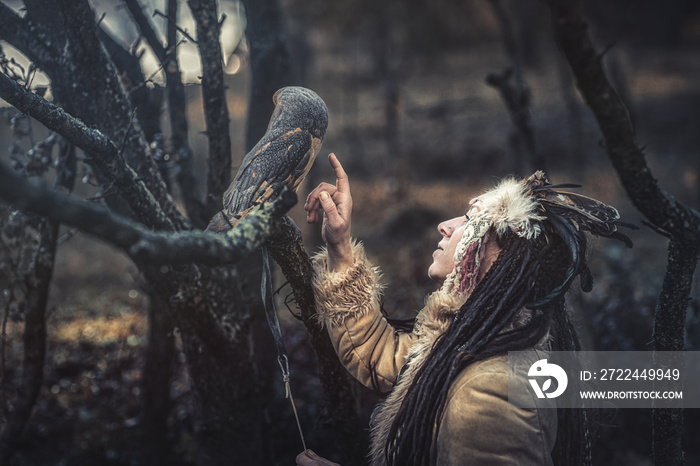 beautiful shamanic woman with owl in the nature.