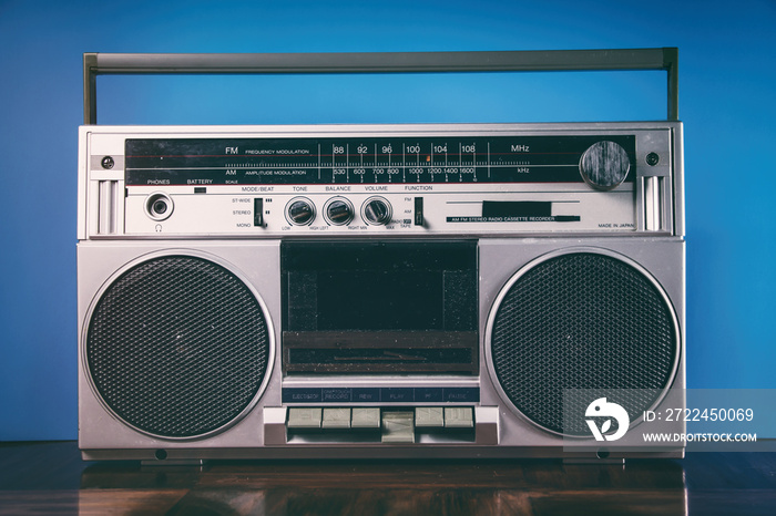 Retro silver boombox against a blue background.