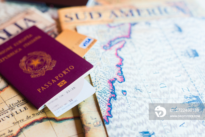 An Italian passport with a smartphone over a tourist magazine of South America, on a light background.