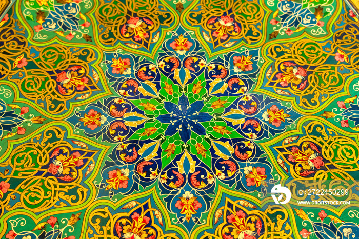 Colorful vintage oriental ornament painted on the tabletop. Abstract background.