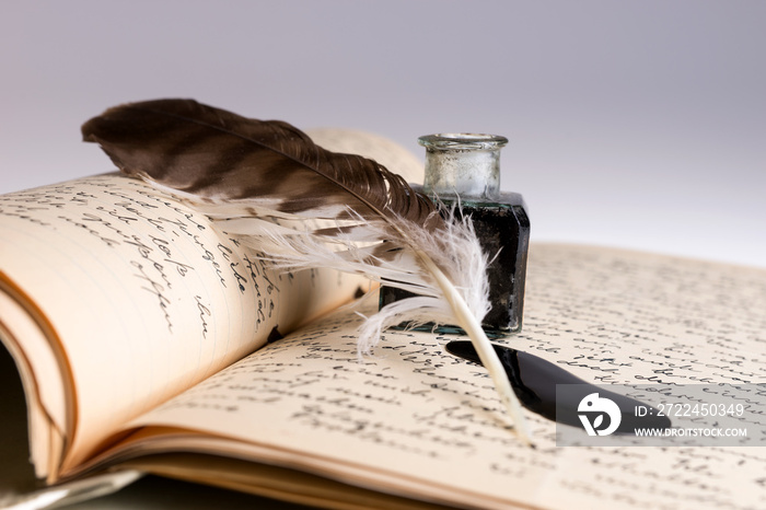 Old writing feather and ink spot with handwritten letter in background