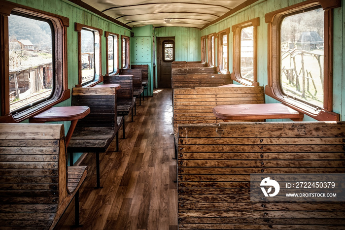 Interior of railway passenger carriage. Vintage atmosphere. Wooden benches and historic railway design.