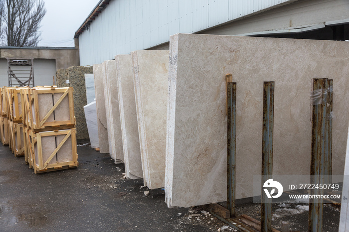 Side view of the edge of the granite slab in bulk. A stack of granite slabs - marble factory. Background of marble slabs. Natural stone. Background of granite slabs. Granite slabs ready for sale