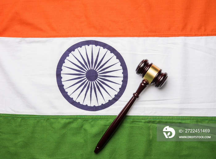 stock photo showing Indian low and jurisdiction - Indian national flag or tricolour with wooden gavel showing concept of law in India