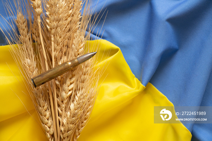 Ears of wheat and a bullet lie on the national flag of Ukraine, yellow and blue, Stop the war in Ukraine and peace to all, glory to Ukraine, protection