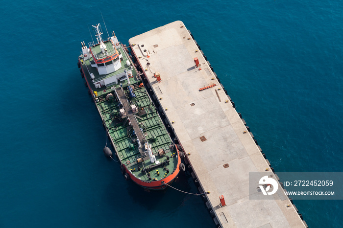 Tanker ship with green deck is moored in port