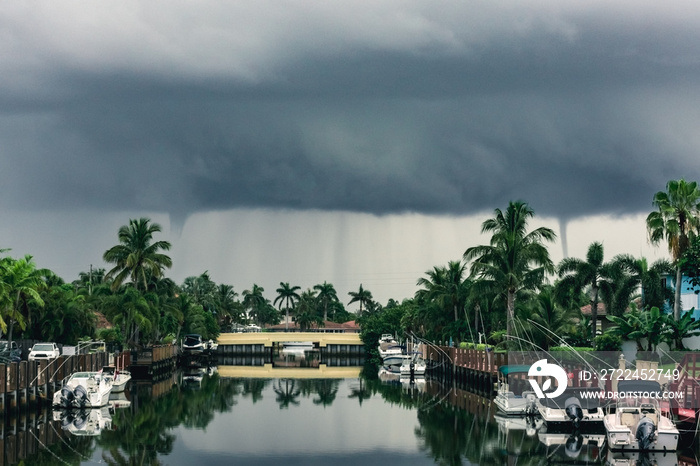 rain and funnel clouds at the edge of a summer morning storm over a south florida river