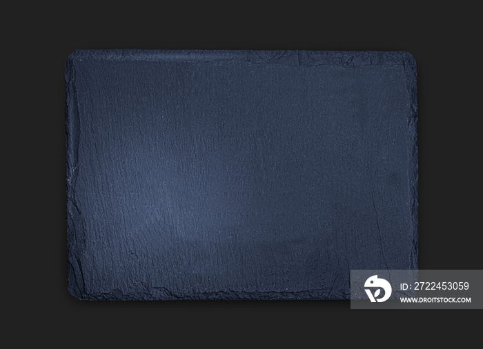 Gray slate board on black wooden table close up photo, natural texture with copy space