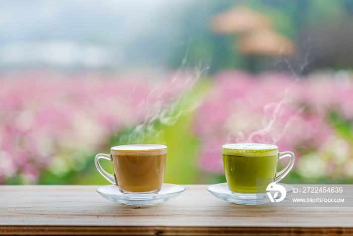 Cups of green tea and Coffee on wood table red flowers park background.