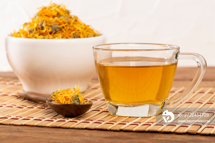 A cup of herbal medicinal tea dried calendula and marigold flowers