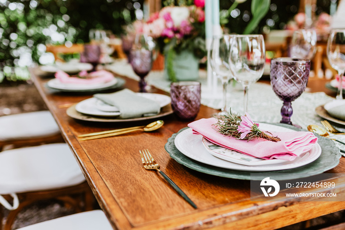 Table setup with flowers, glasses and plates on table decorated for Wedding Reception in terrace Latin America