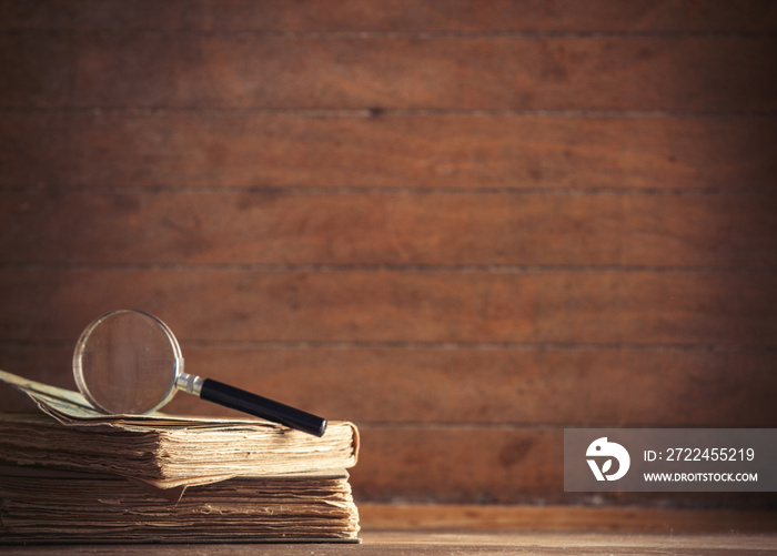 little magnifier and book with map on a table. Image in old color style