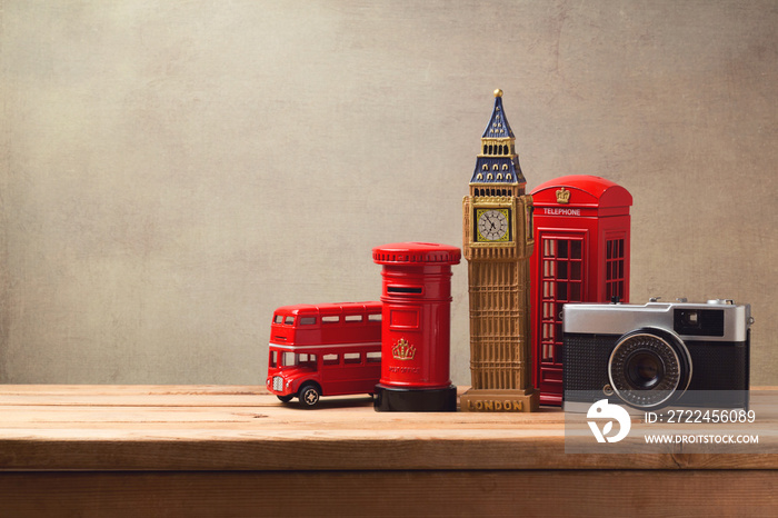 Travel and tourism concept with souvenirs from London and vintage camera on wooden table with copy space