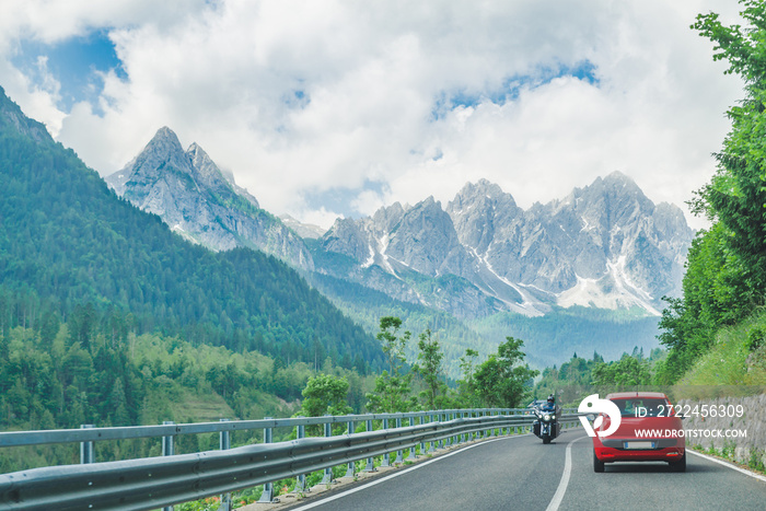 small red car on the road through mountains road trip