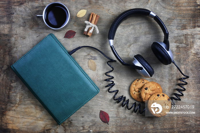 audiobook headphones and book on wooden table