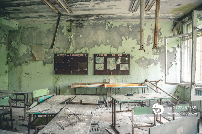 ruined class room with desks and blackboards in Pripyat school