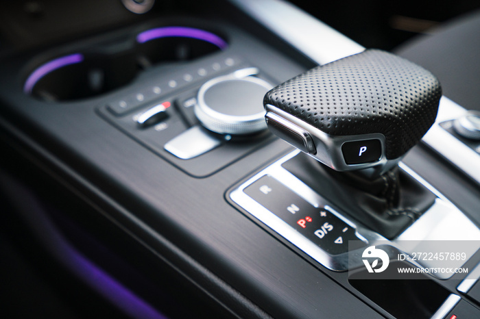 gear shifter knob inside a luxury car with purple neon lights. car interior and high end photography.